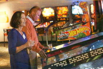 A man and woman in front of pinball machine