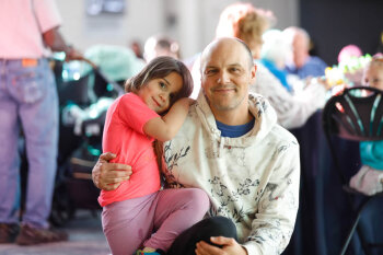 A man holds a young girl for a photo at the George Eastman Circle Family Celebration, held on April 27, 2023 within Rochester New York.