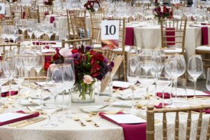 table setting for table ten, tan tablecloth with maroon napkins