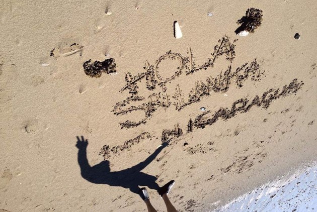 'Hola Sre Lanka from Nicaragua' written in beach sand