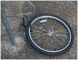 photo of a bike tire locked to a bike rack, after the rest of the bike had been separated from the tire and stolen