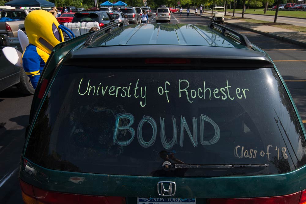 back windshield of a car reads University of Rochester Bound