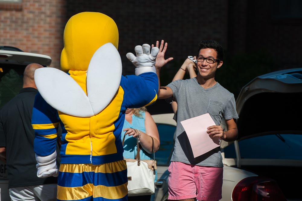 student gives high-five to Rocky mascot