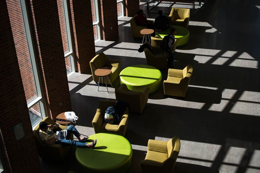 light streaming in through the windows onto the tables and chairs in Rettner Hall