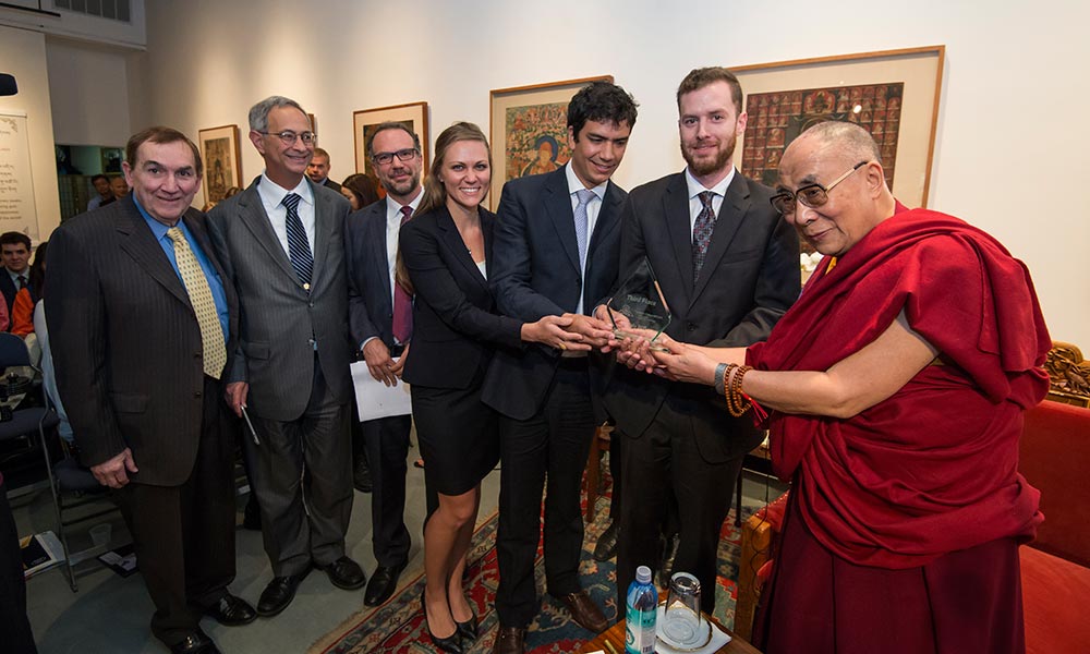 students pose with Dalai Lama after winning award