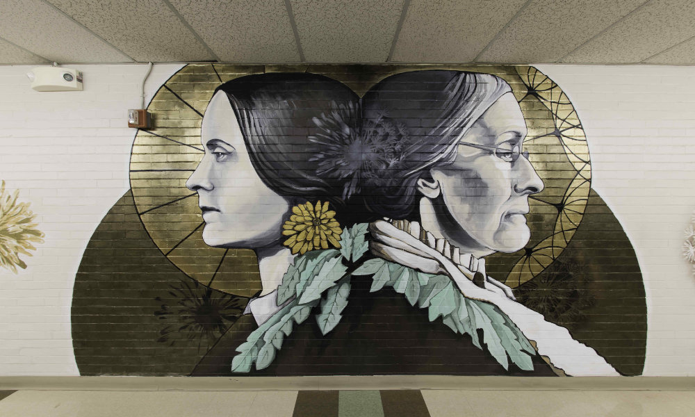 Mural shows a young and old Susan B. Anthony back to back.
