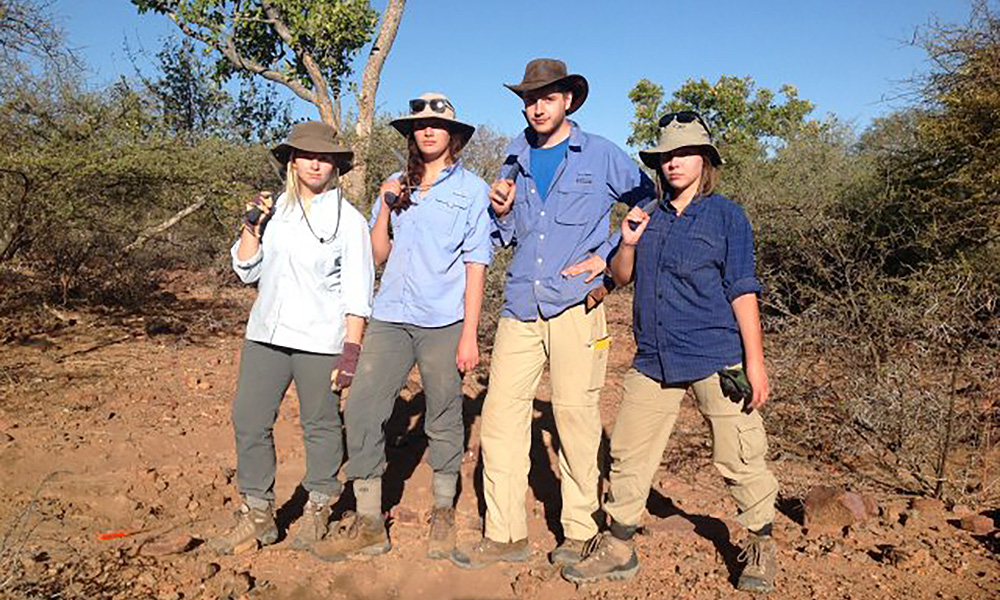 student researchers in the field pose for a photo