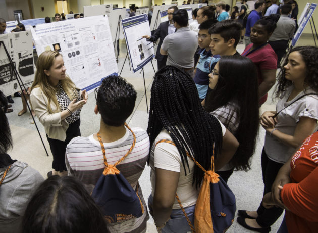 Xerox Research Fellow Rebecca Gillie tells Upward Bound students about her research project at a poster session this summer. (Photo by J. Adam Fenster/University of Rochester)