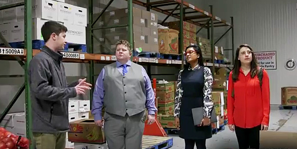 four students standing in warehouse