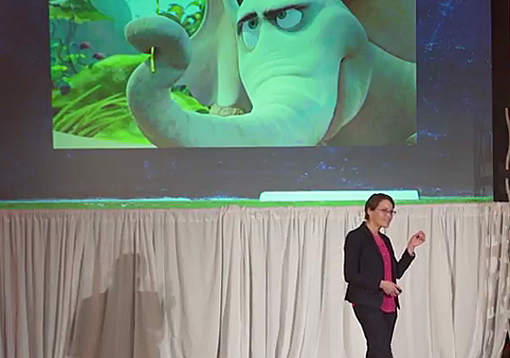 professor in front of a screen with an image of an animated elephant