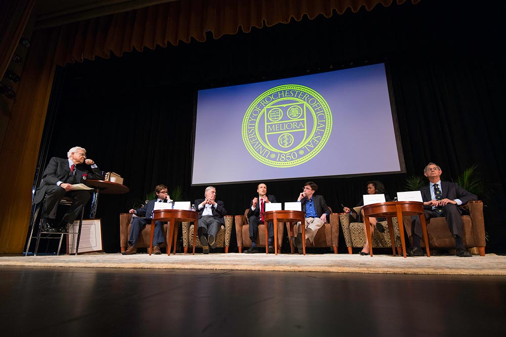 panel of speakers seated on stage