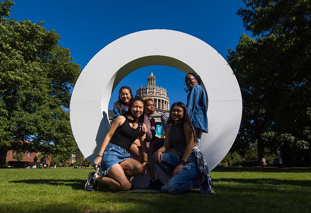 students pose inside giant letter O