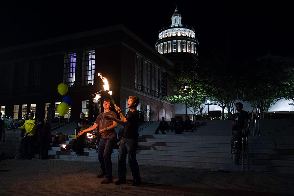 juggling fire in front of Rush Rhees Library