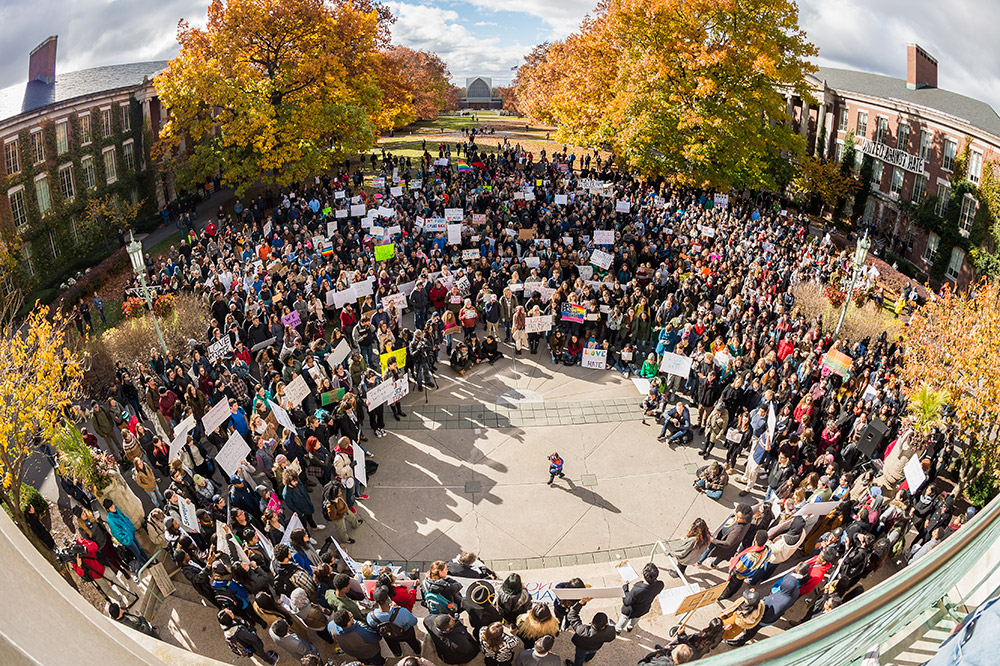 large group of demonstrators standing in a circle on the quad