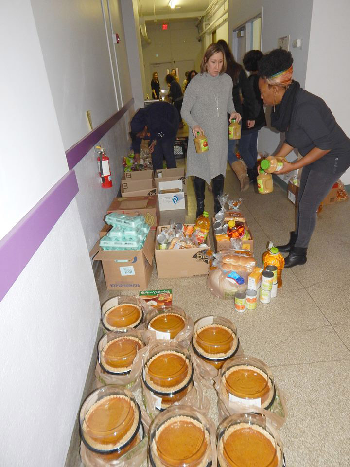 two people organizing pumpkin pies and other food items