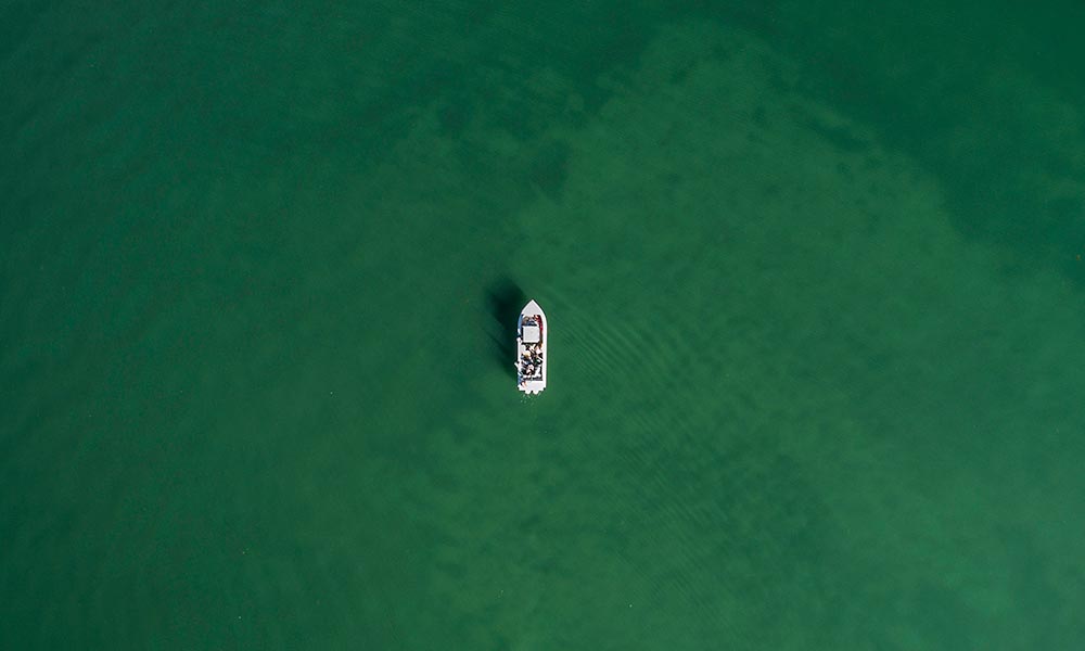 overhead view of a boat surrounded by water.