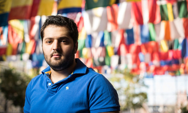 Omar Soufan stands in front on display of world flags