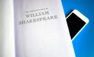 book of William Shakespeare with smartphone peaking out behind it