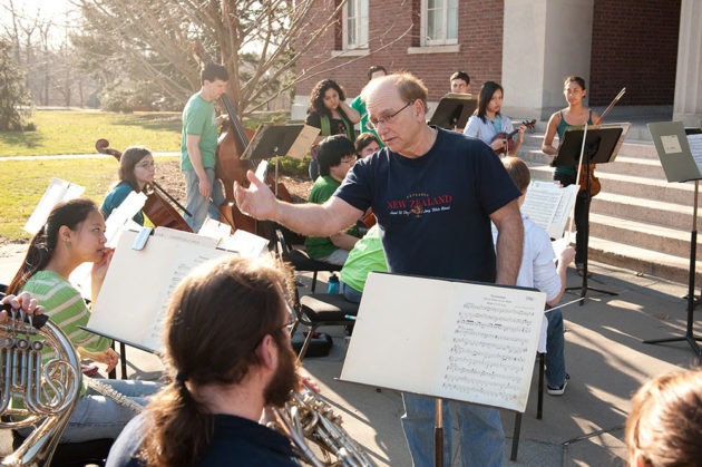 Man teaching orchestra class outside Rush Rhees library
