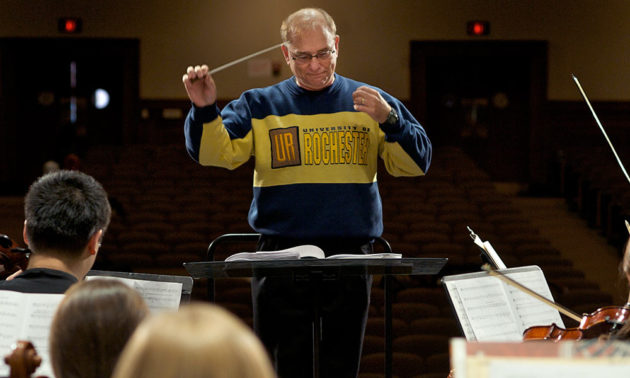 man conducting, wearing UR sweater