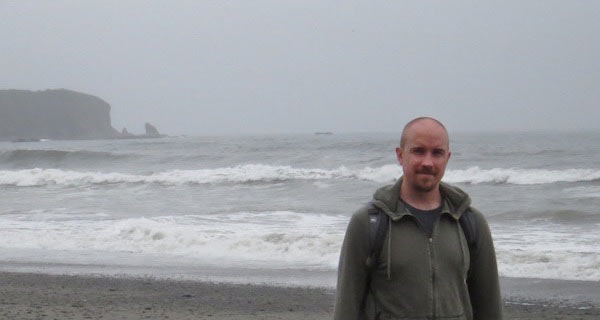 man on a foggy beach studying climate systems