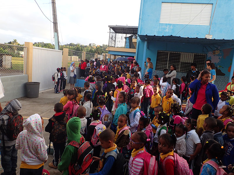 large group of people standing outside a school