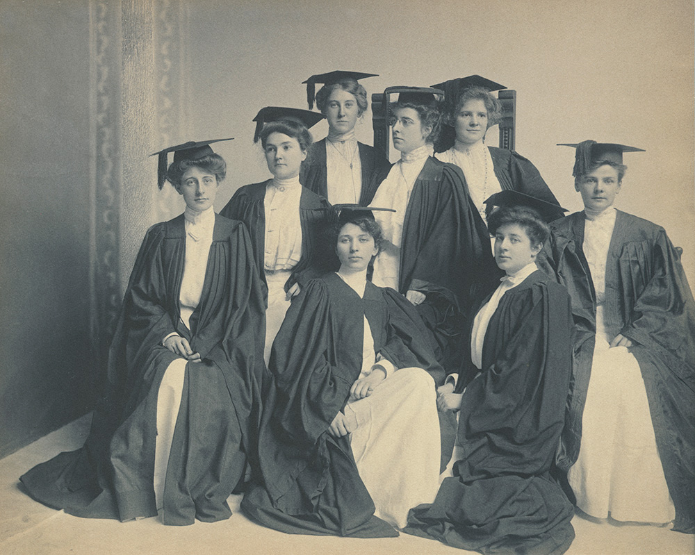women in Victorian attire and graduation robes.