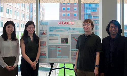 four students by their poster