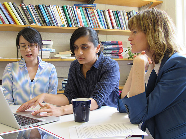 three researchers sitting around a laptop