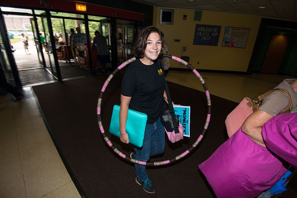 student carrying hula hoop