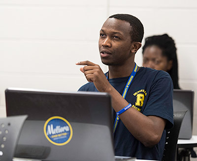 student sitting behind a computer with a MELIORA sticker