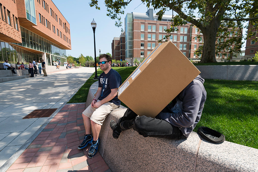two students, one with his head inside a large cardboard box