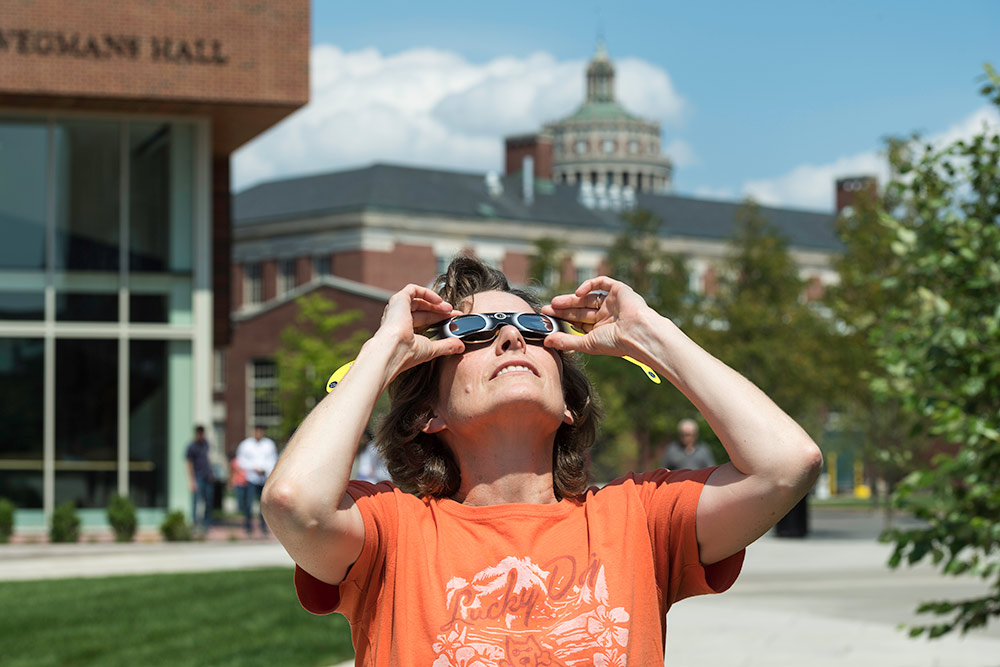 woman with eclipse glasses looking up