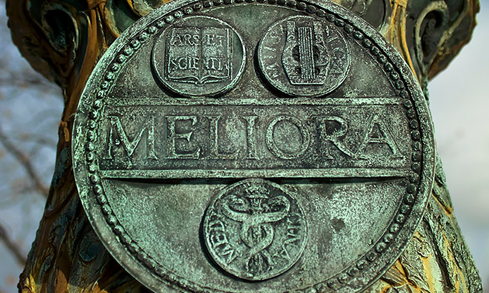 closeup of Meliora engraving at base of flagpole.