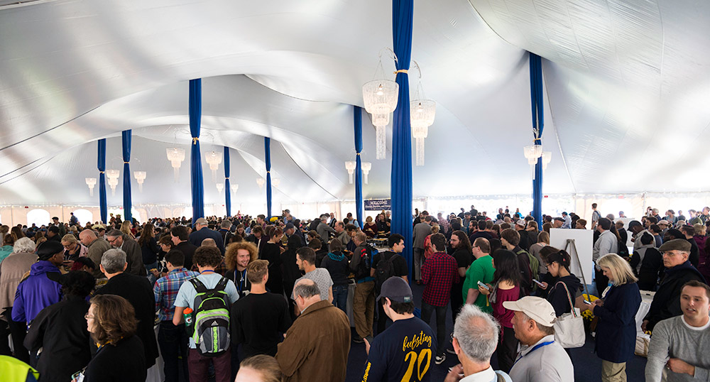 crowds in a tent with chandeliers