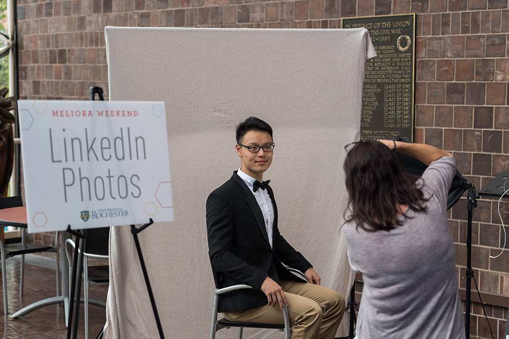 photographer takes a photo of a young man in a bow tie)
