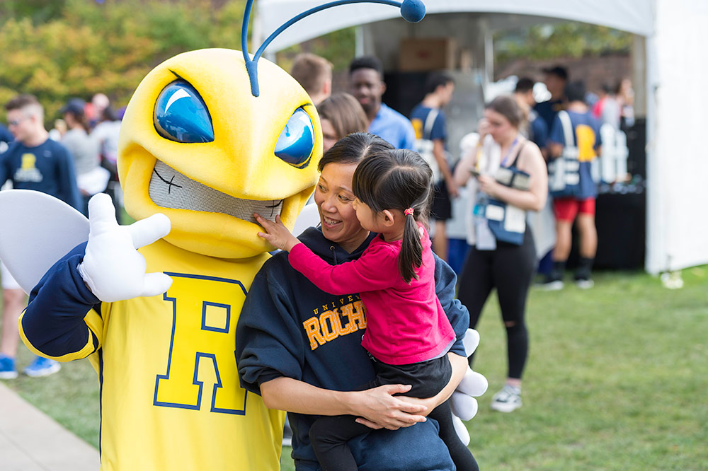 woman and child talking to a Yellowjacket mascot