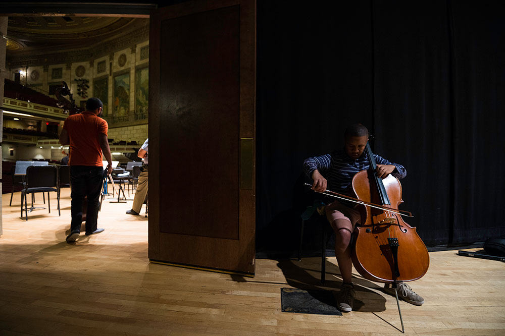 musicians practicing cello backstage
