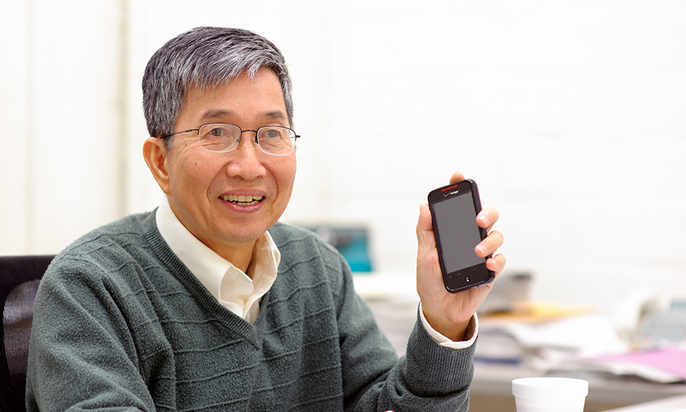 Ching Tang holding up a cellphone