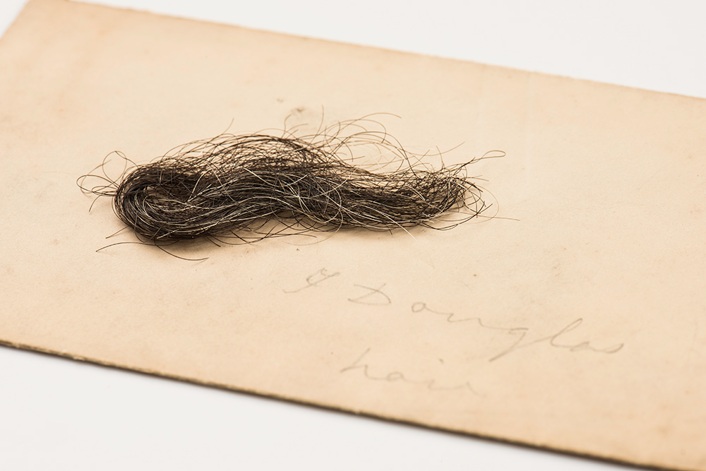 lock of hair on a piece of paper with the hand written words Frederick Douglass