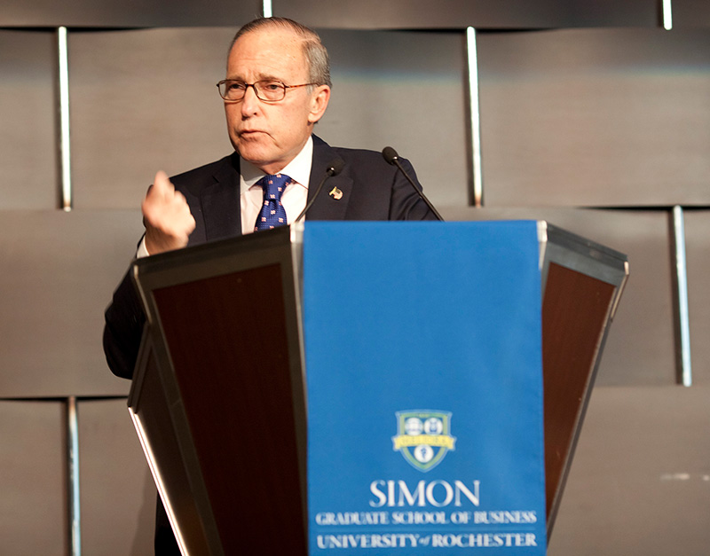 Larry Kudlow speaking at a Simon Business School podium