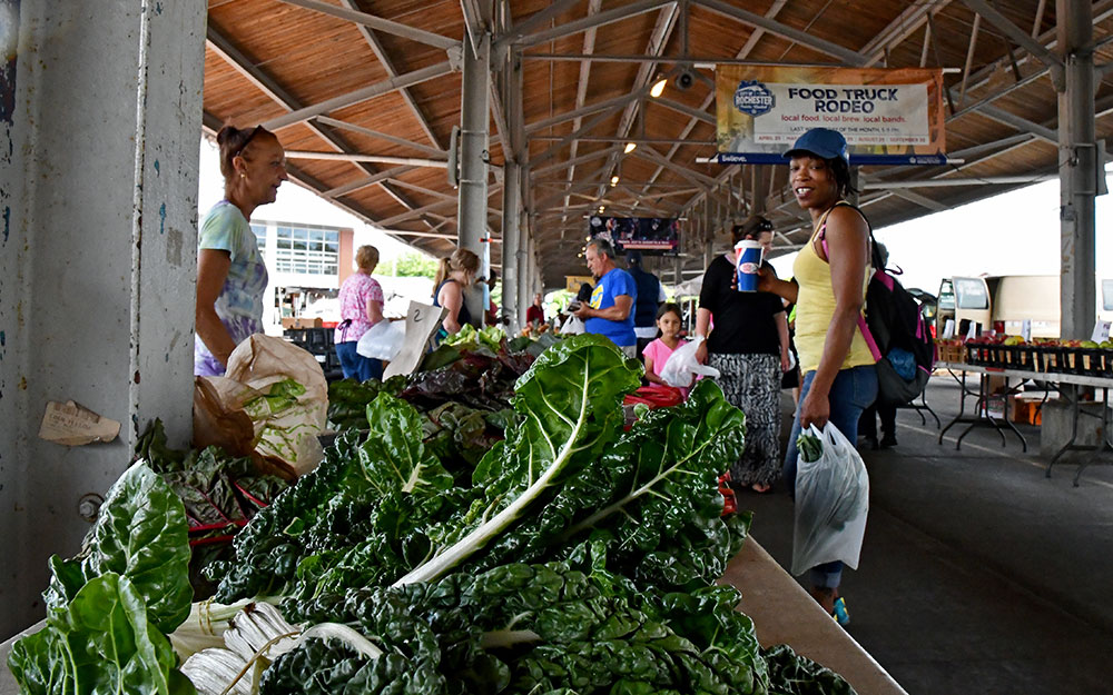 close-up of market produce with shoppers in the background