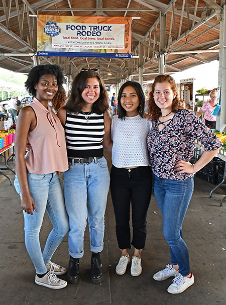 portrait of four students at the Rochester Public Market