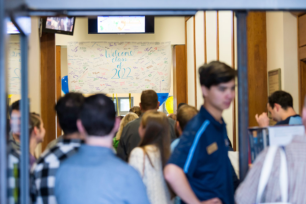 large crowd of students standing under a sign that reads CLASS OF 2022