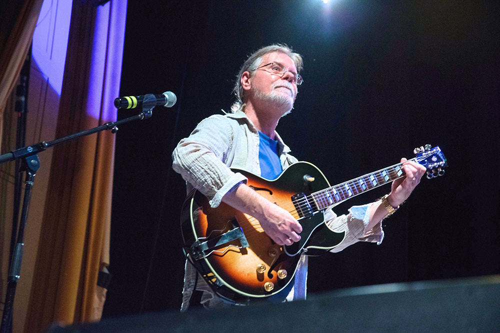 John Covach on stage playing guitar