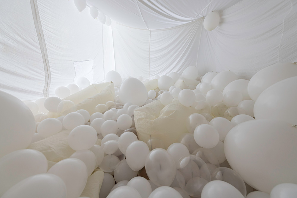 a white room completely full of white balloons