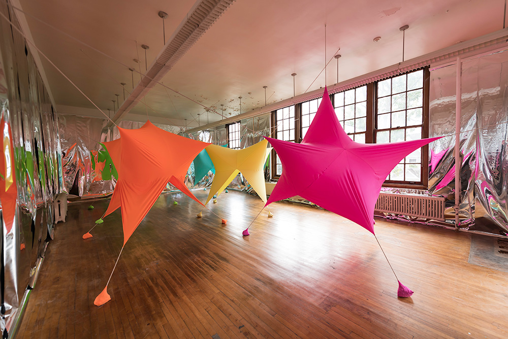 large room filled with colorful, star shaped balloons