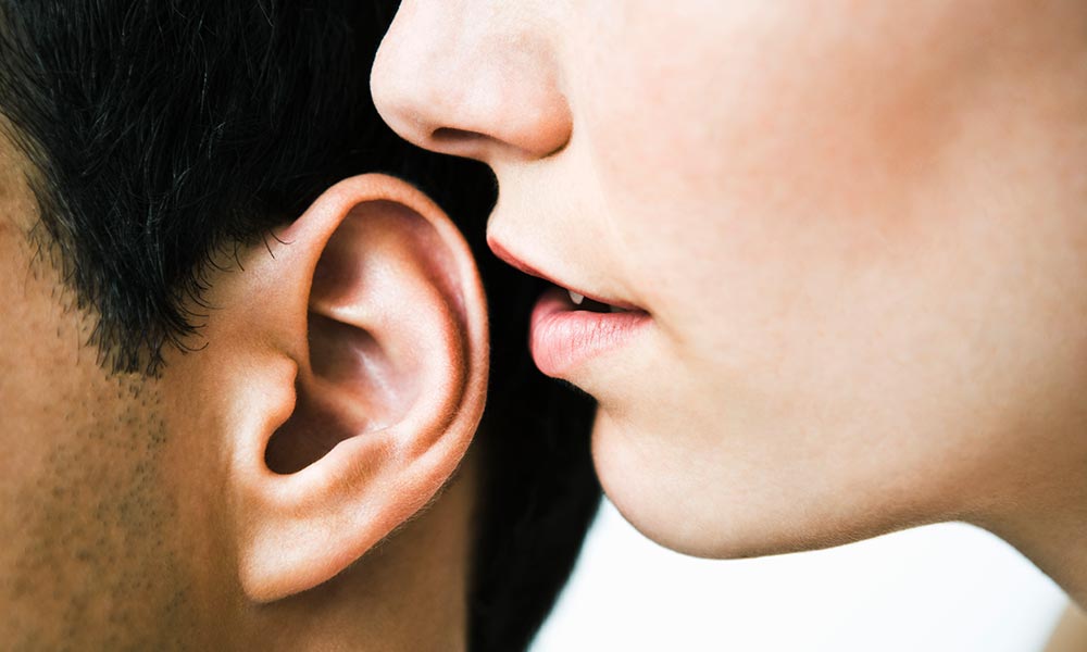 woman whispering in an ear