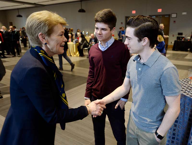 Sarah Mangesldorf shaking hands with students