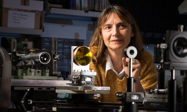 Jannick Rolland in her lab surrounded by lenses and other optical equipment.